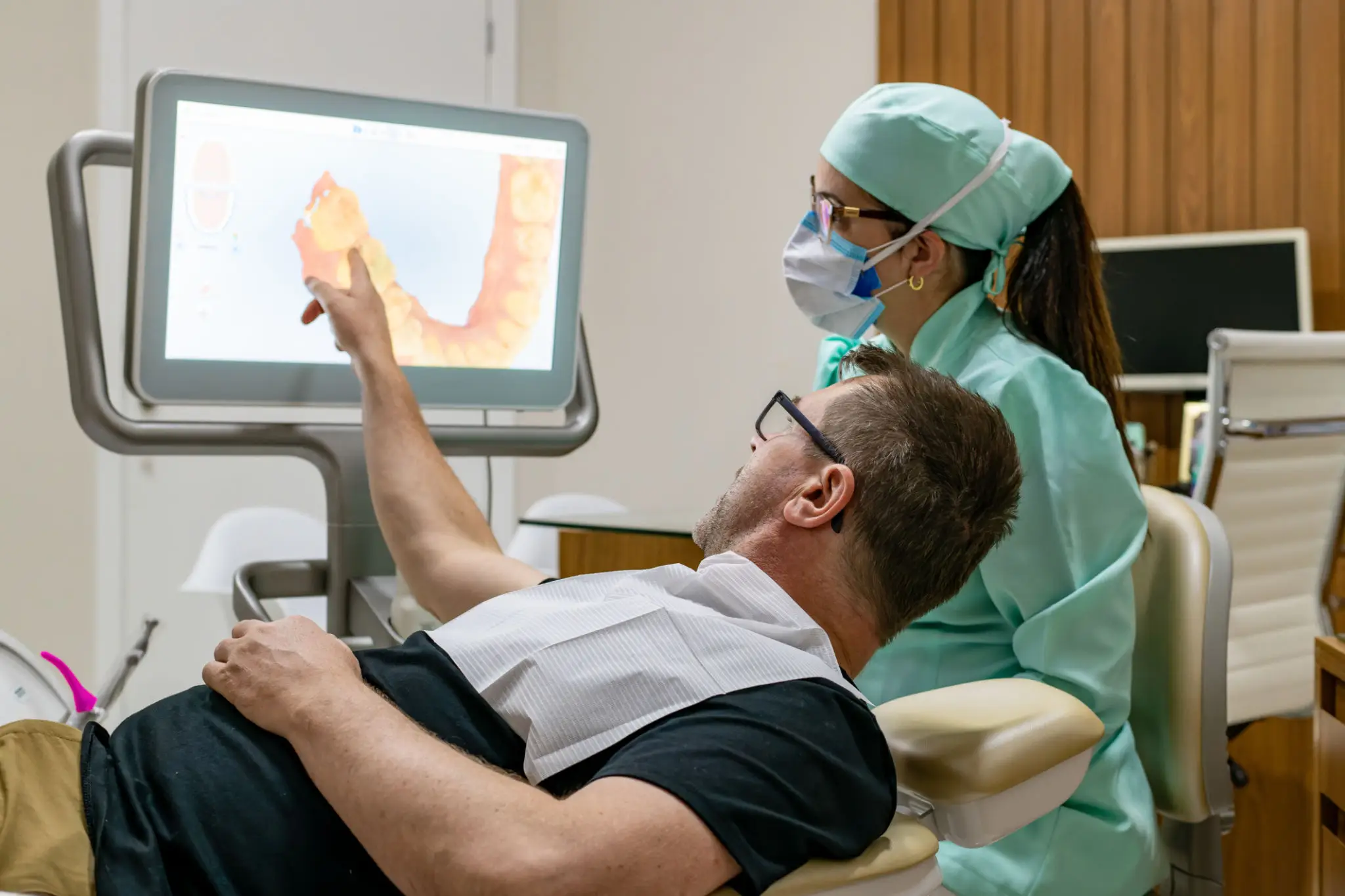 Dentist showing dental X-ray to patient in clinic.