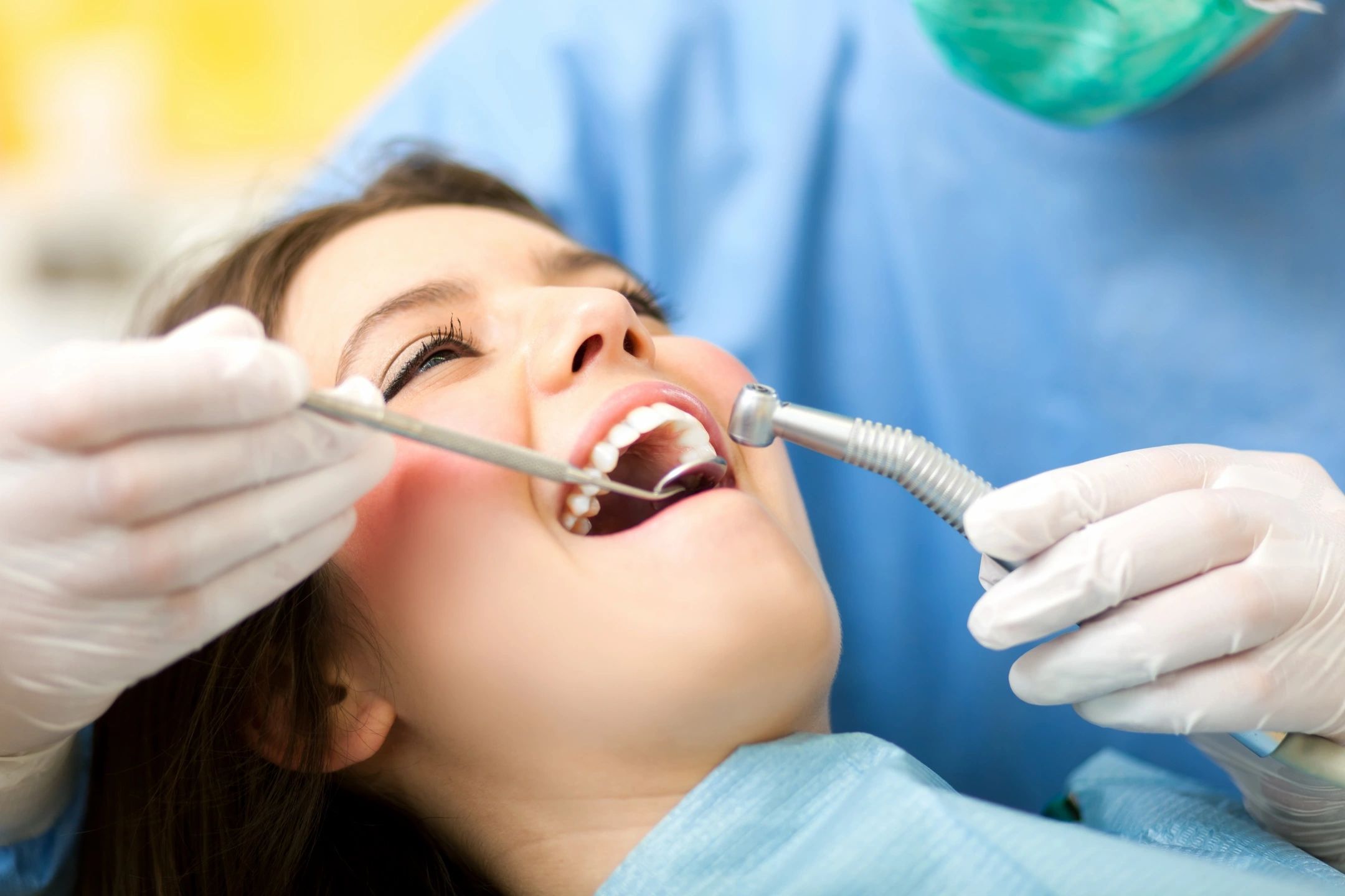 A woman receiving dental treatment from a dentist.