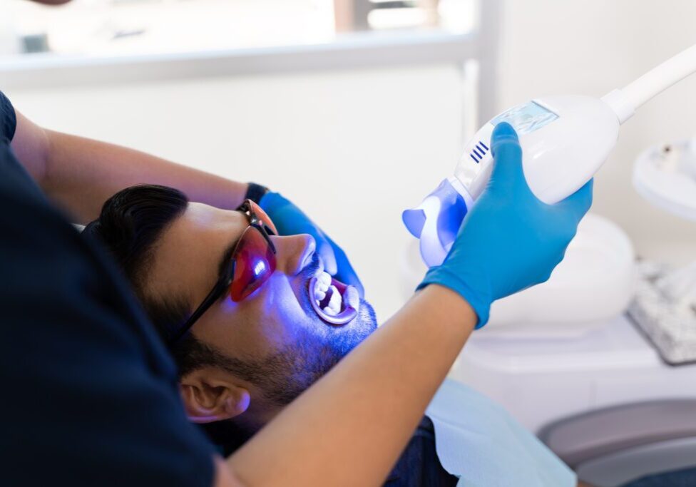 Patient receiving dental treatment with UV light.